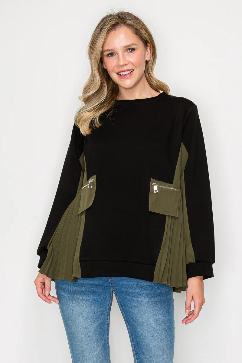 Woman wearing a black and olive green top with pocket details on a white background